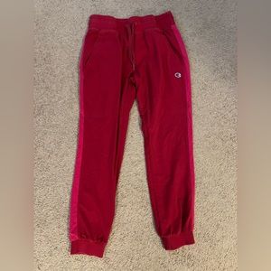 Red Champion sweatpants with light red/pink panelling on side of leg detail.